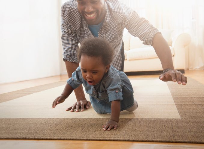father crawling and playing with baby