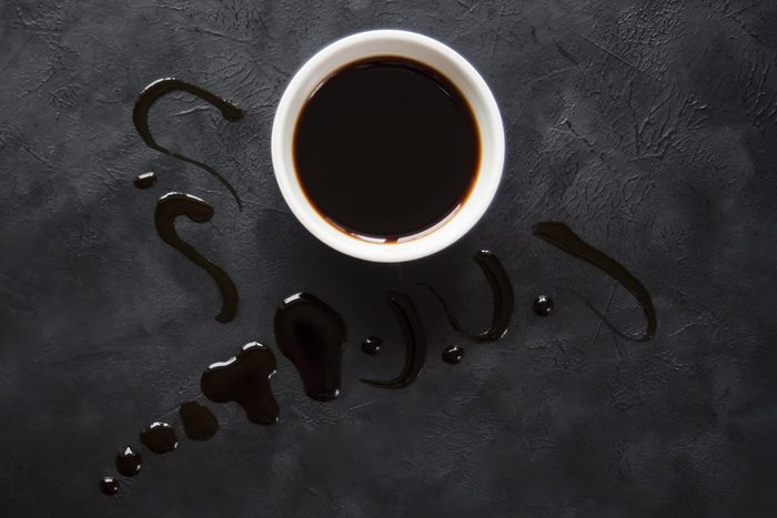 Puddle of soy sauce on a black table.