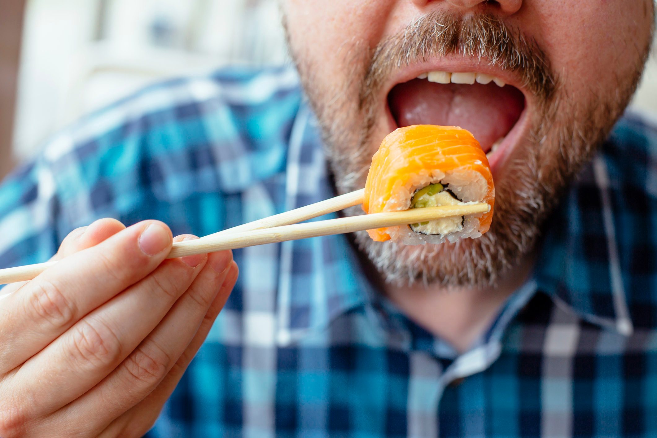 close up of man eating sushi