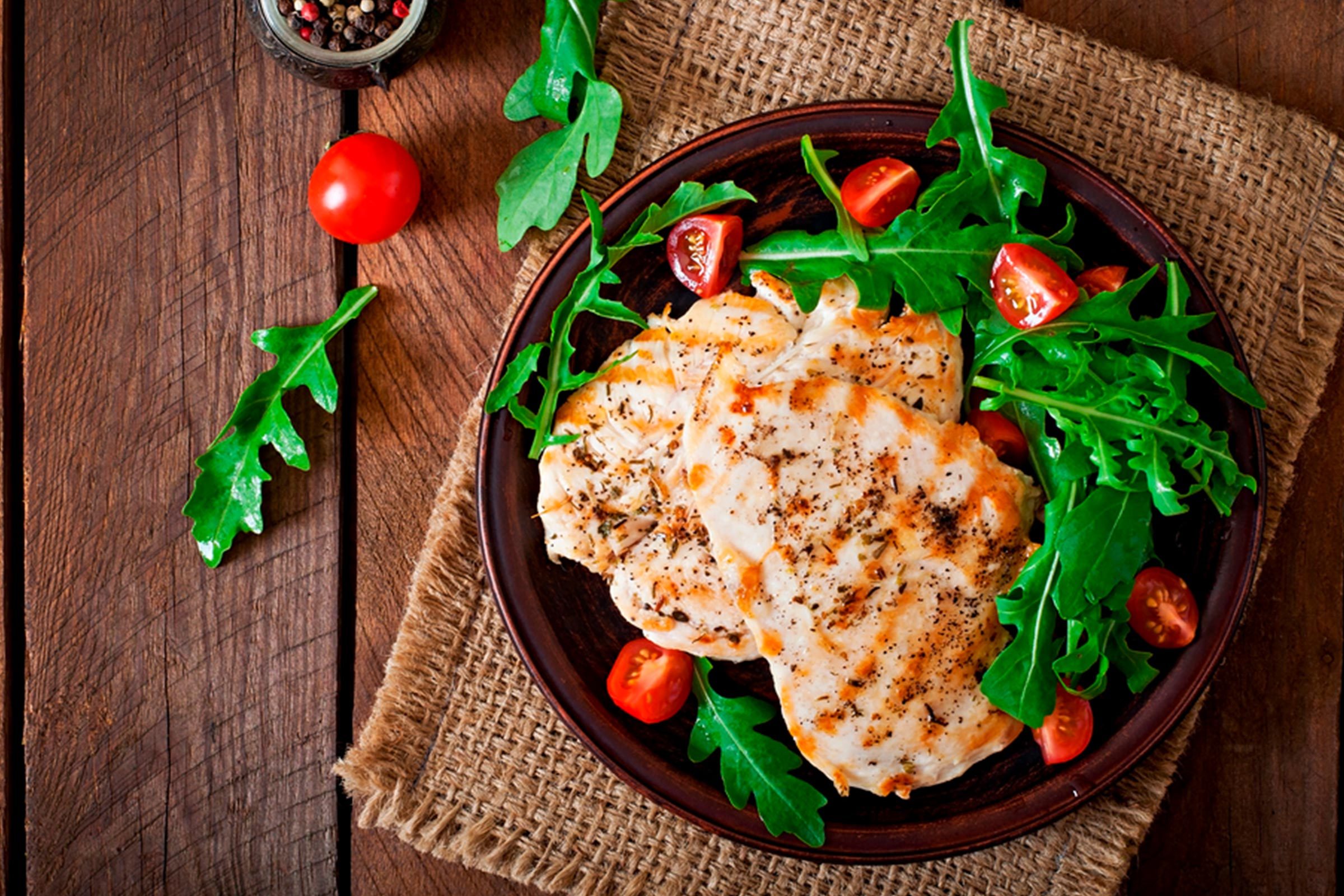 Plate of grilled chicken and veggies on a table