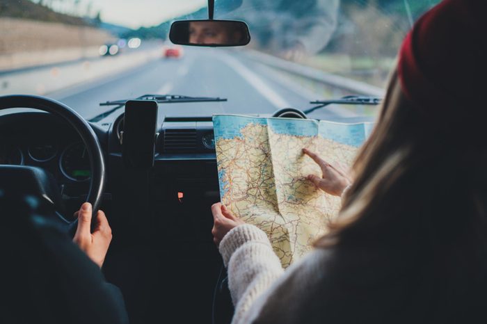 man driving and woman reading map in the car