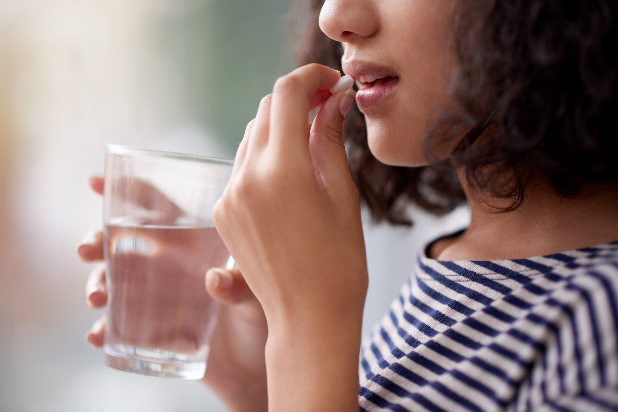 close up of woman taking a pill