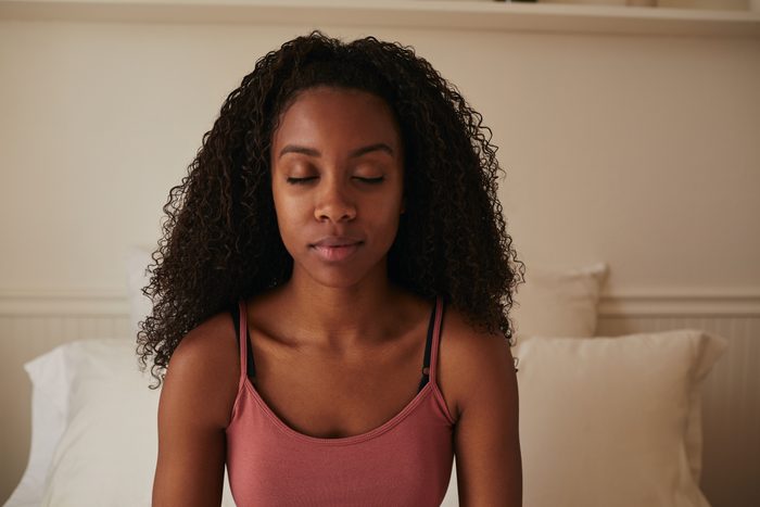 woman meditating in bed