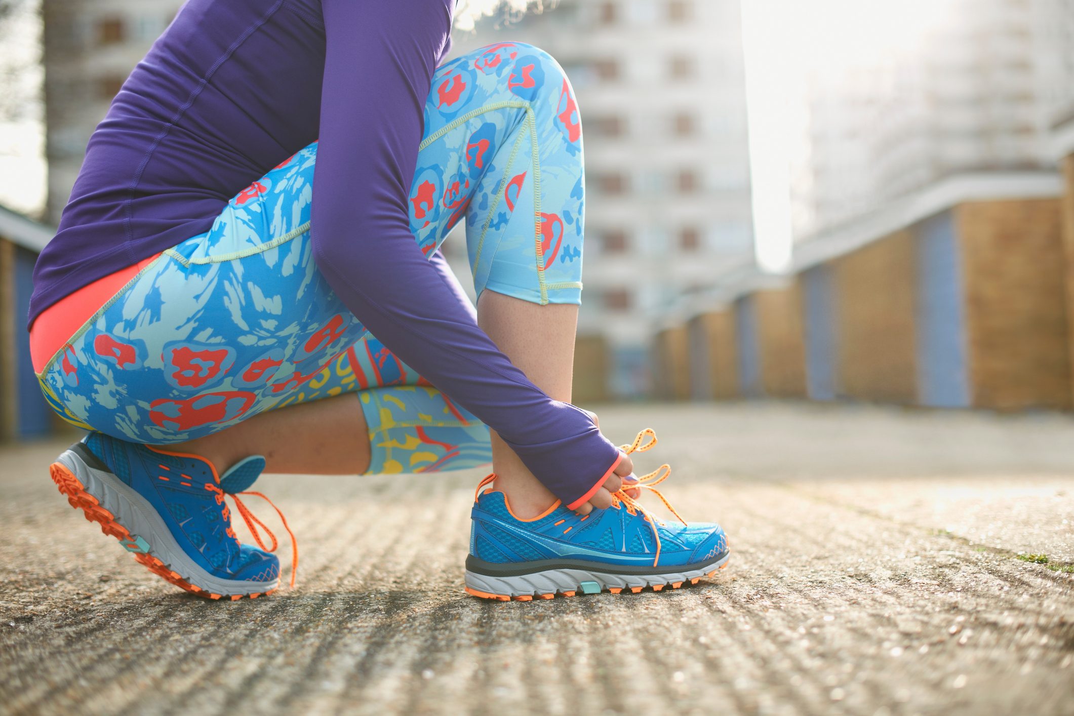 cropped shot of woman tying sneakers