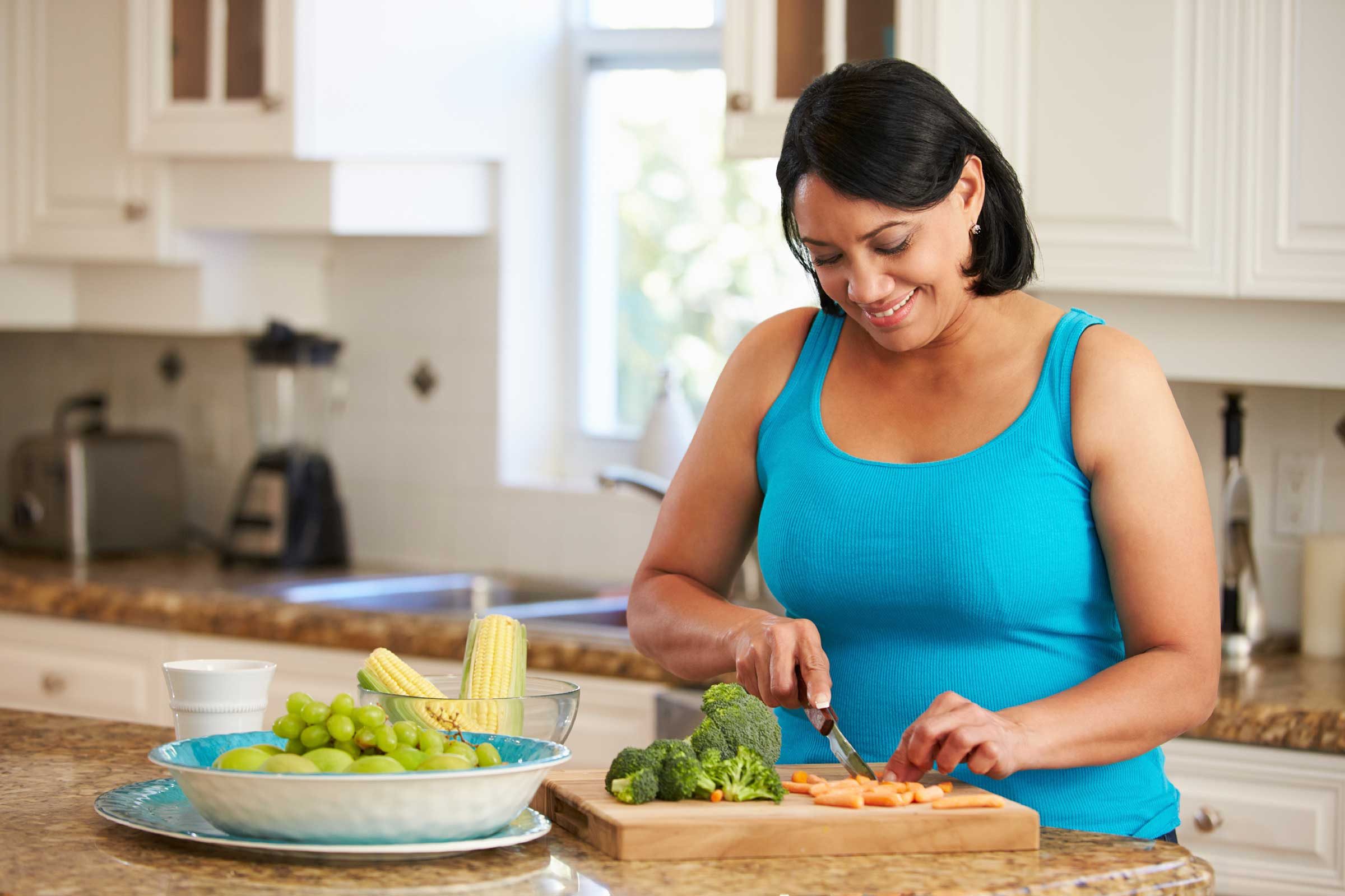 woman cutting up vegetables in the kitchen