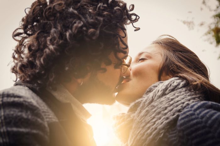 couple kissing with sun in background