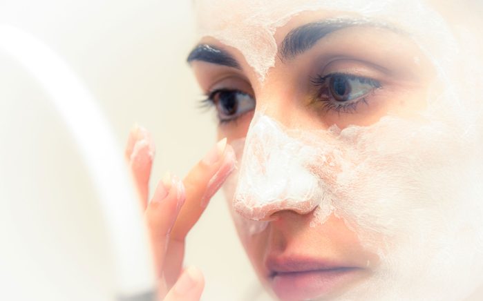 woman applying moisturizer to her face