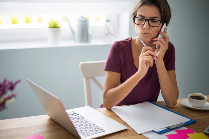 woman on phone sitting at computer