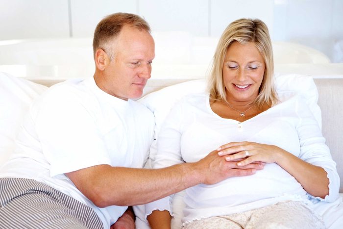 man with hand on pregnant woman's belly