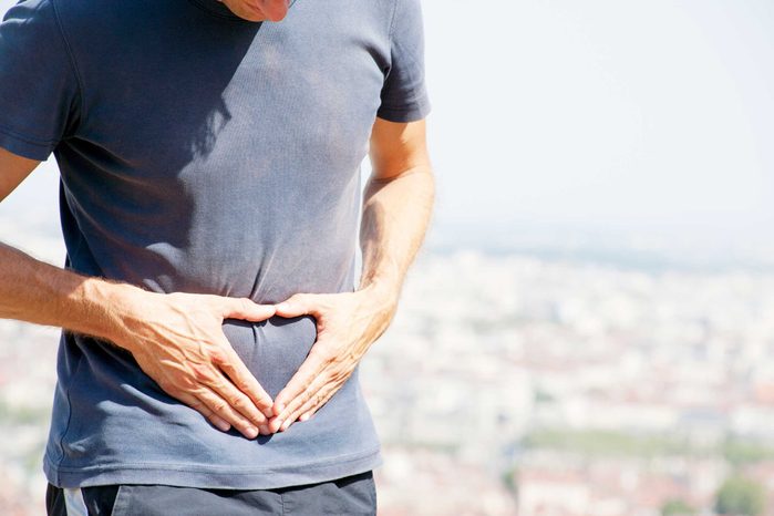 man with hands on abdomen