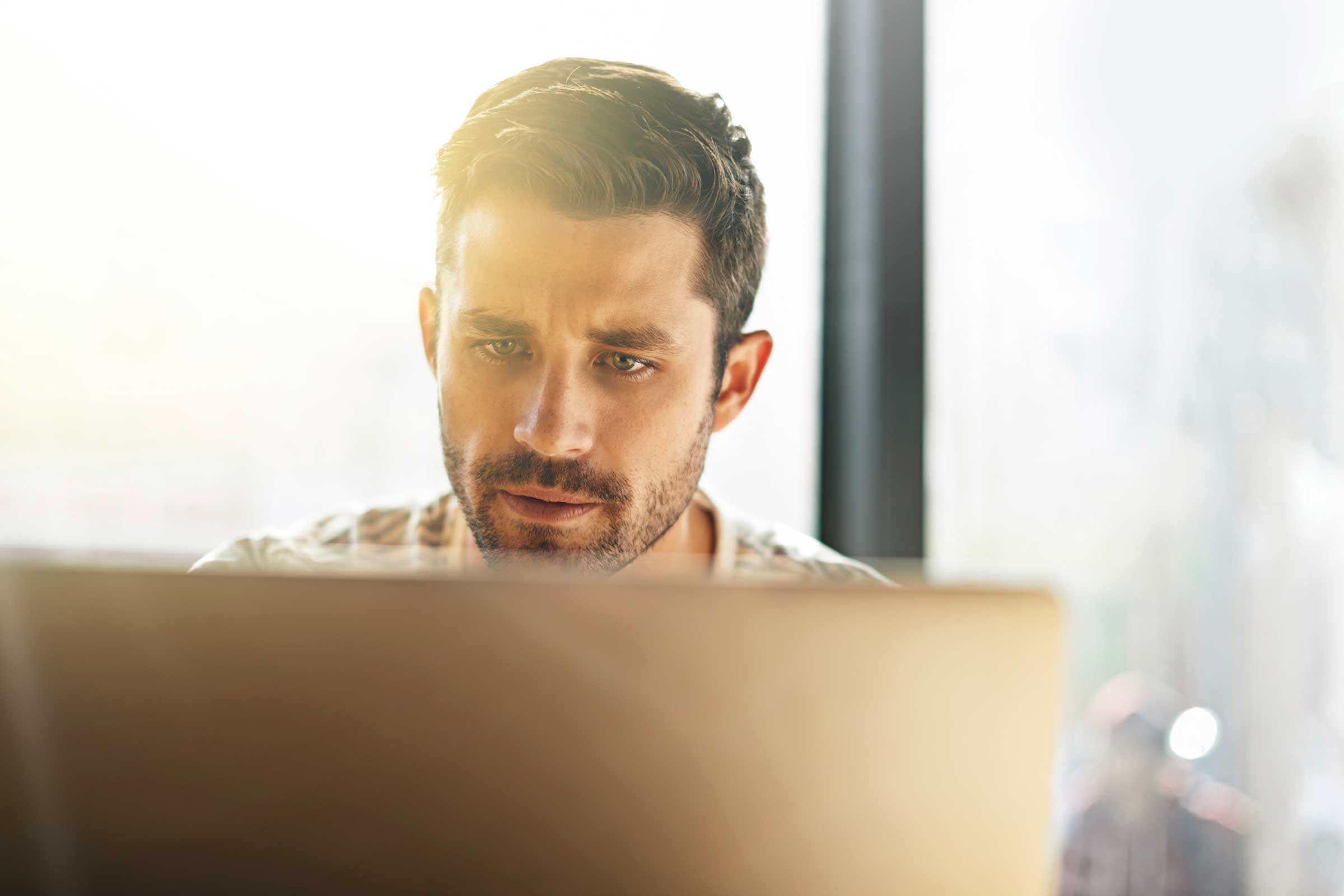 Man looking at computer screen just below eye level.