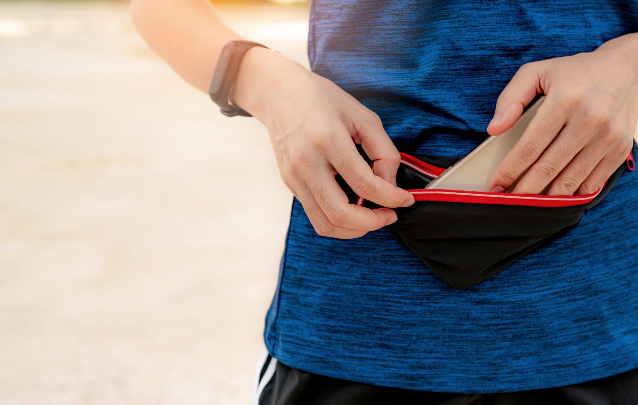 woman putting phone into fanny pack