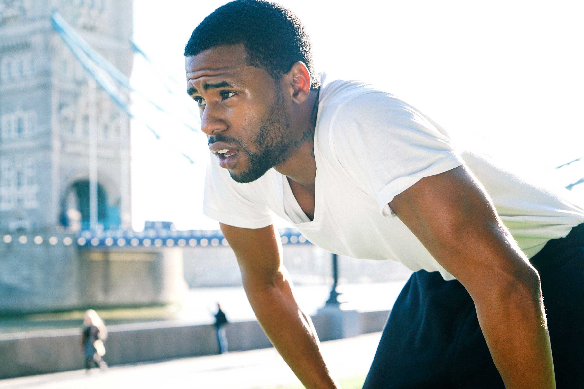 sweaty man with hands on knees, looking fatigued