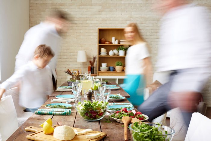 family taking seats at dinner table