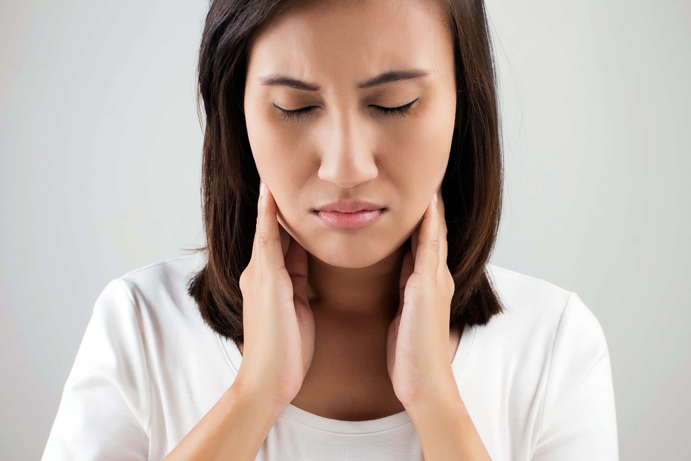 Woman in pain touching sides of her neck