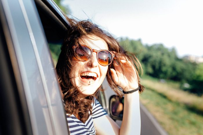 woman sticking head out car window