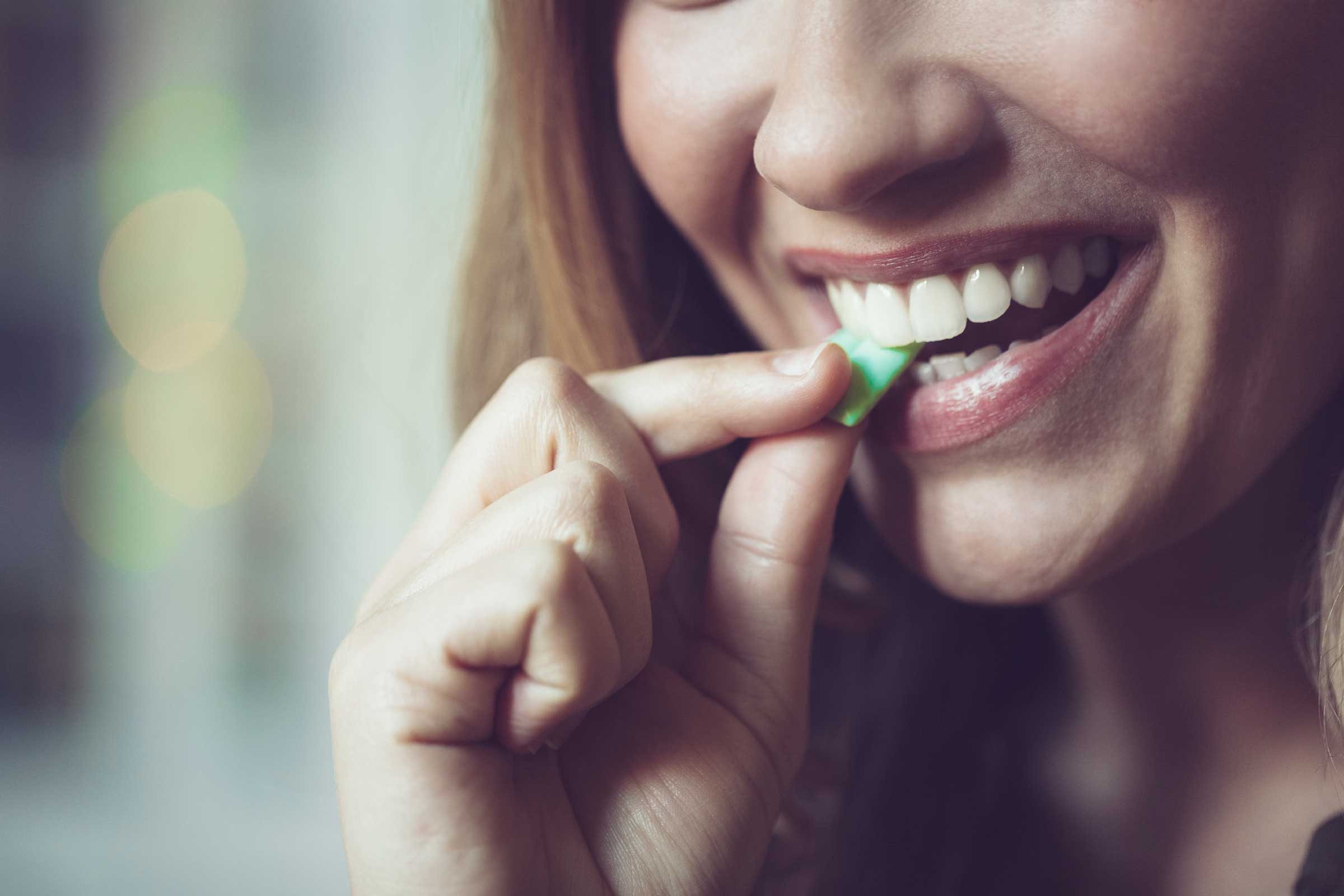 woman biting a piece of gum