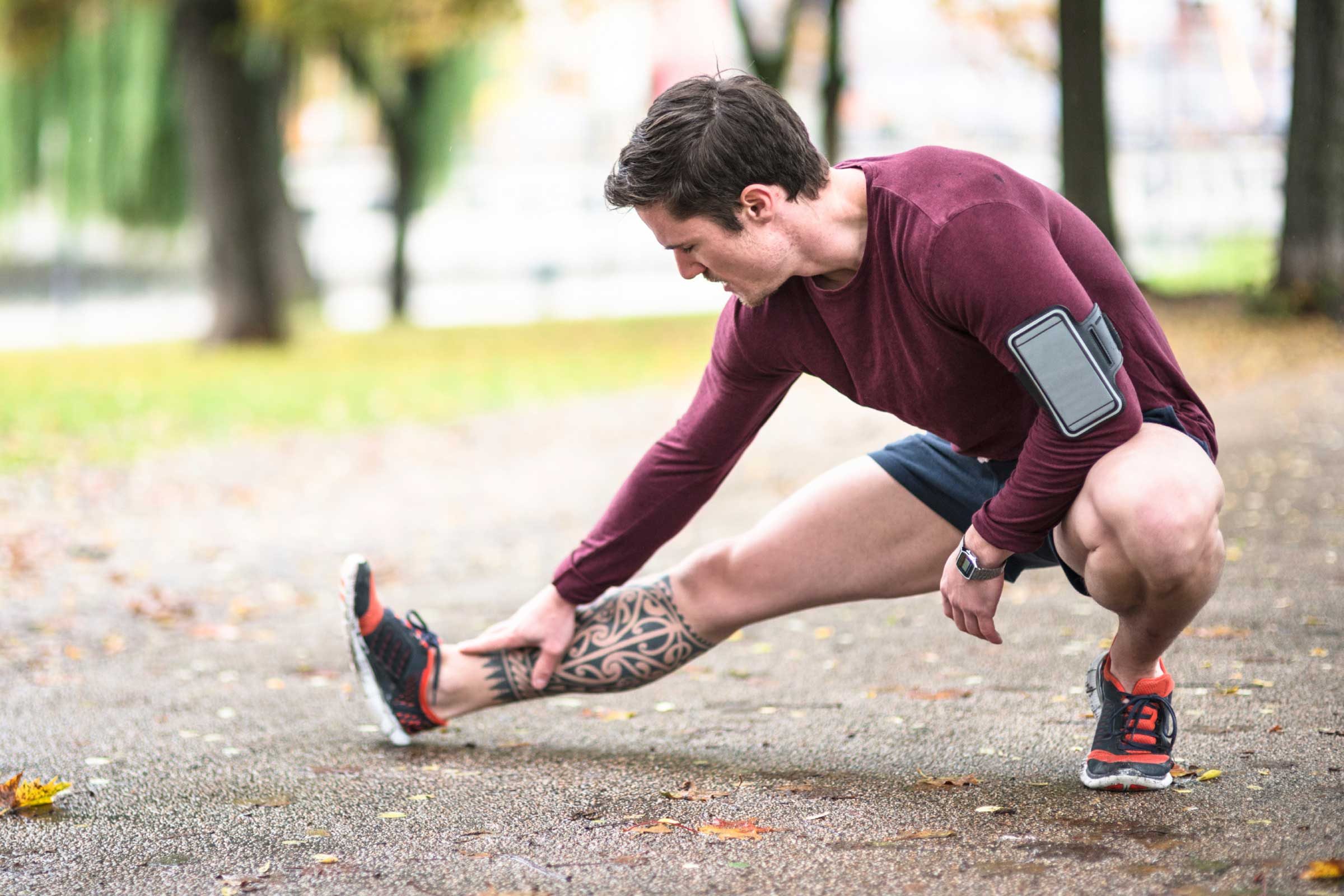 male runner stretching