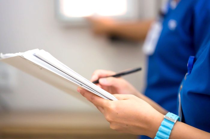 nurse writing on clipboard