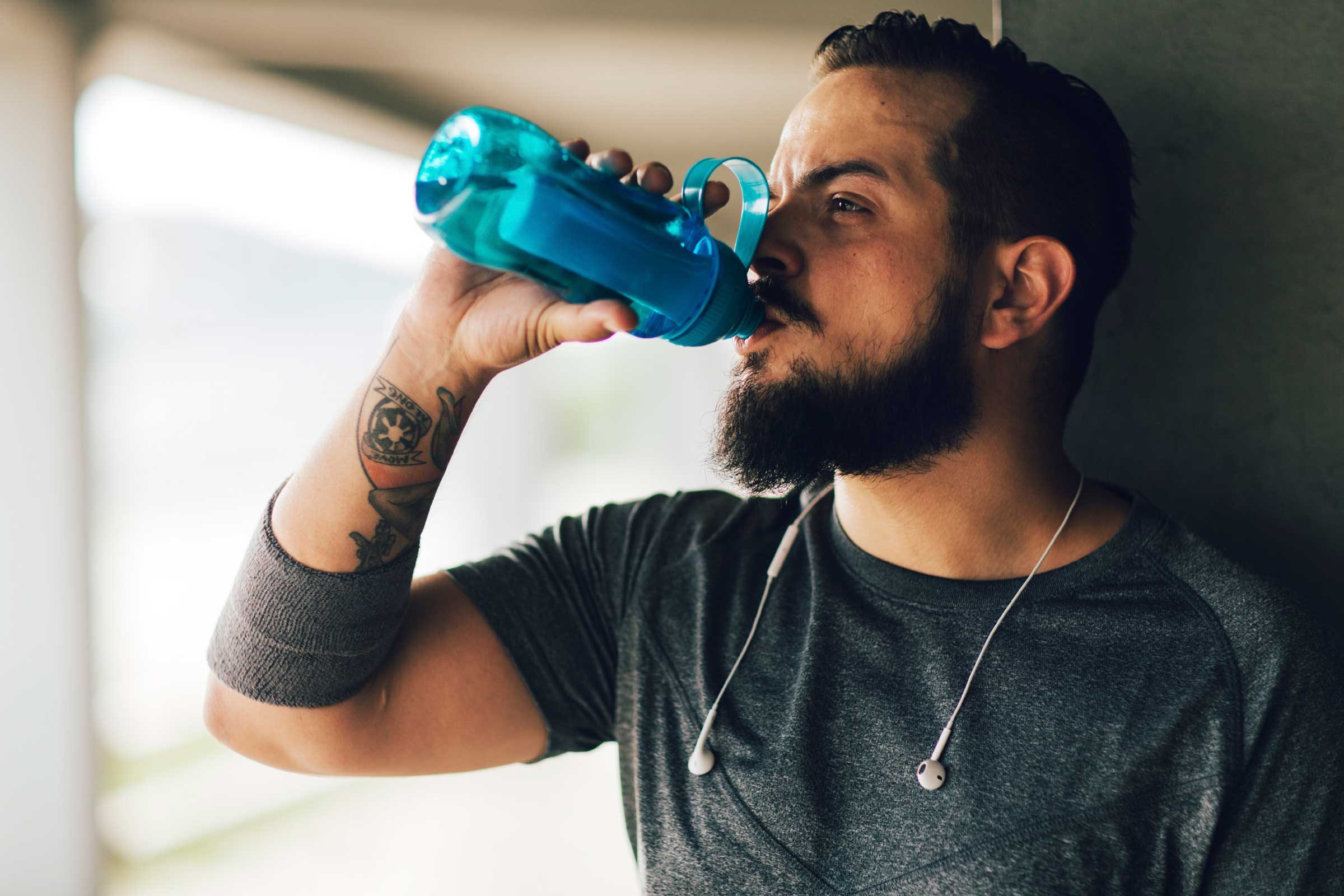 Man sipping water from a water bottle.