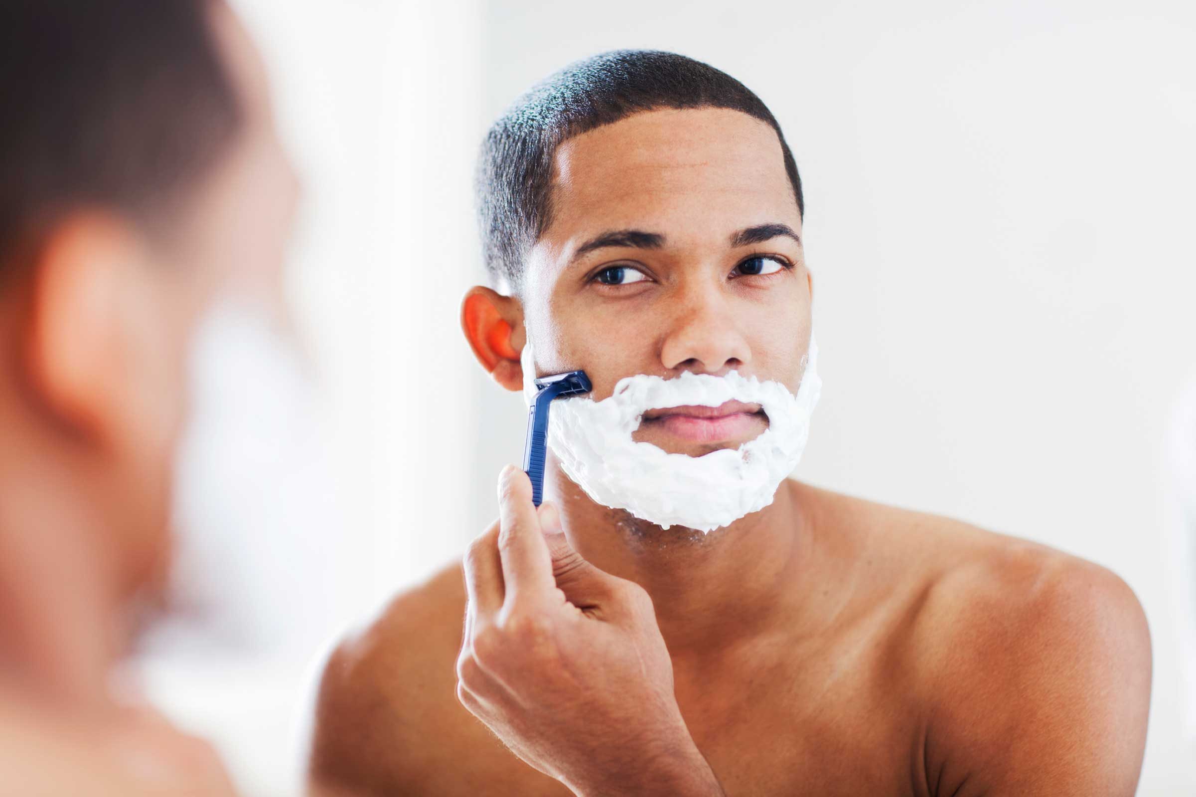 African American man shaving his face.