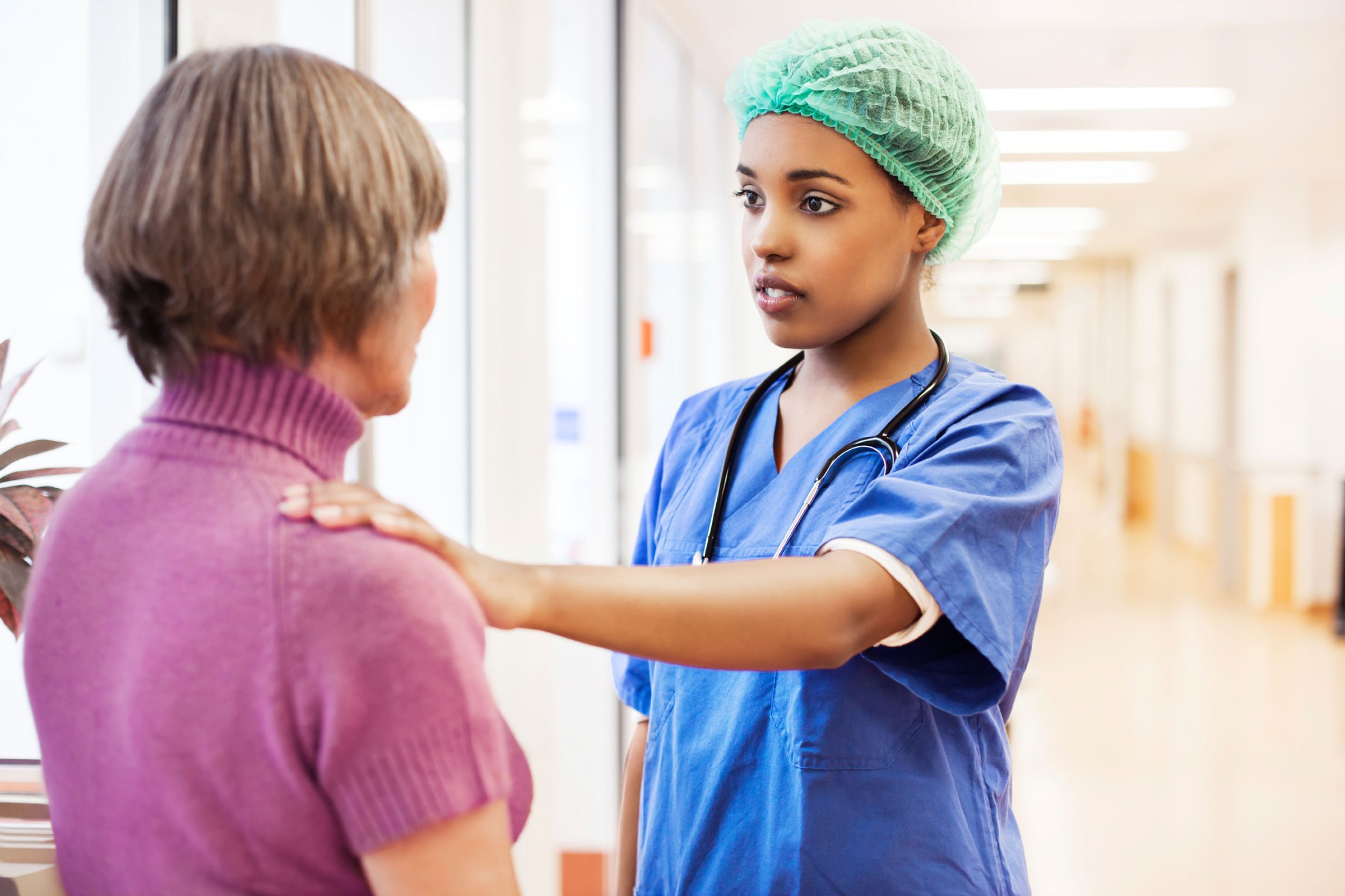 surgeon talking to woman in hospital corridor