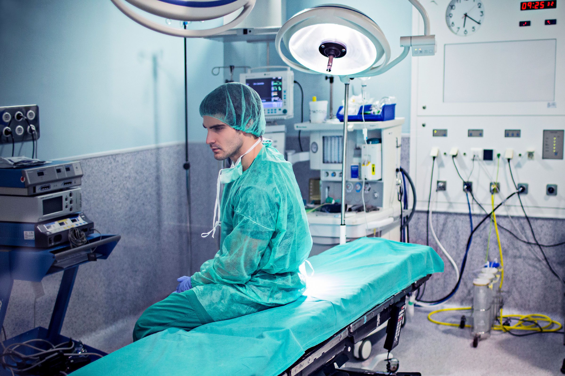surgeon sitting on gurney in operating room