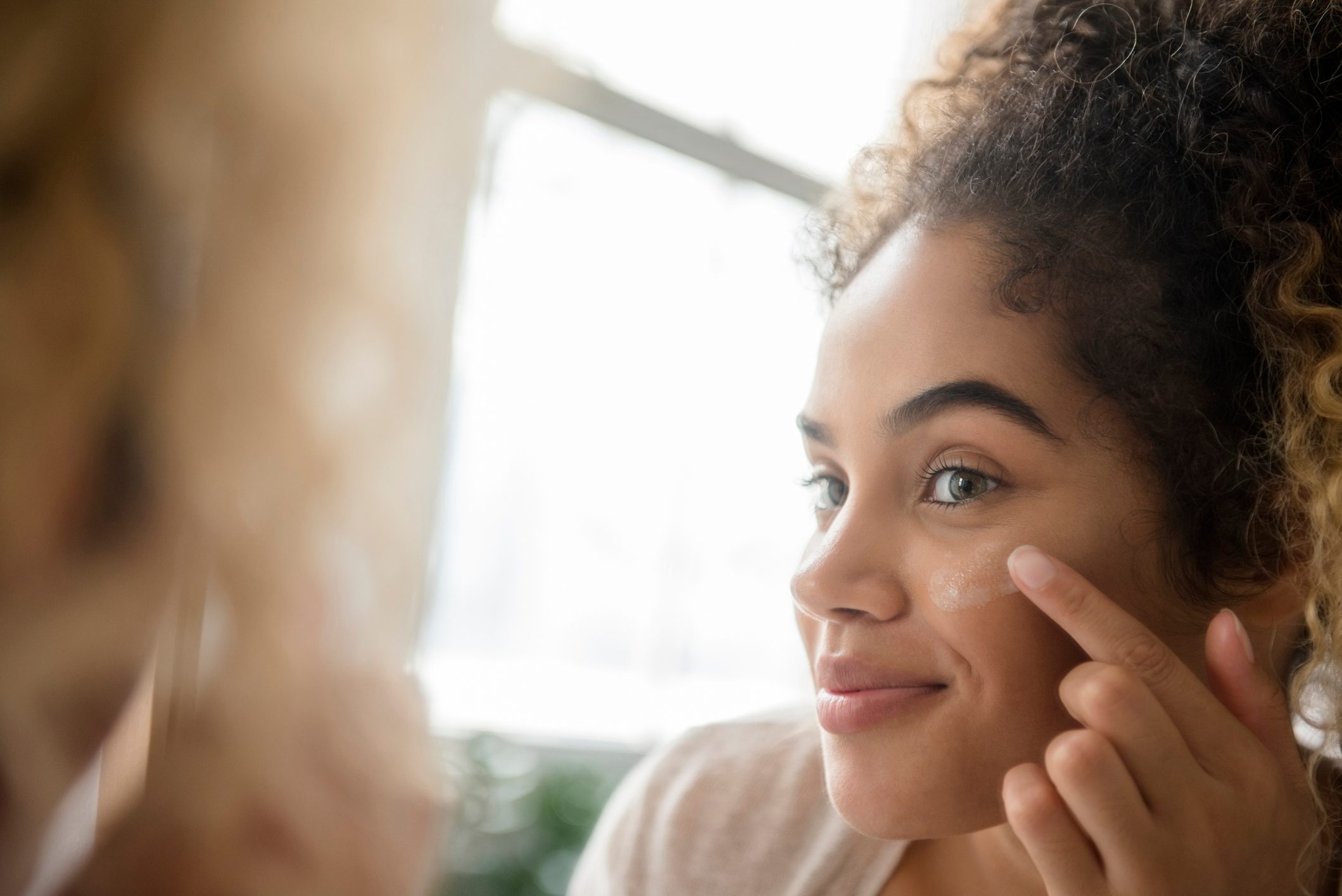 woman applying cream on face
