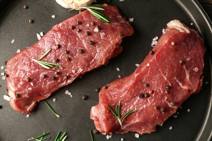 Fresh raw meat with spices on plate
