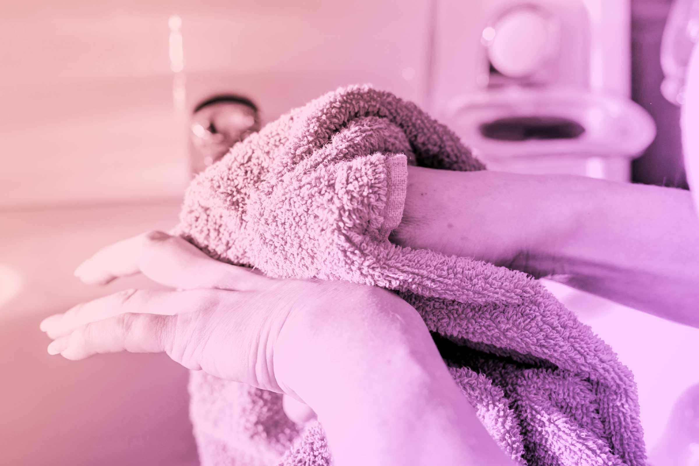 person drying hands with wash cloth