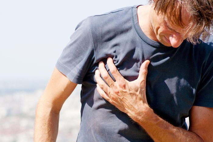 man hunched over, grabbing his chest