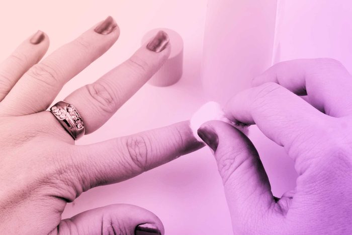 person removing nail polish with nail polish remover