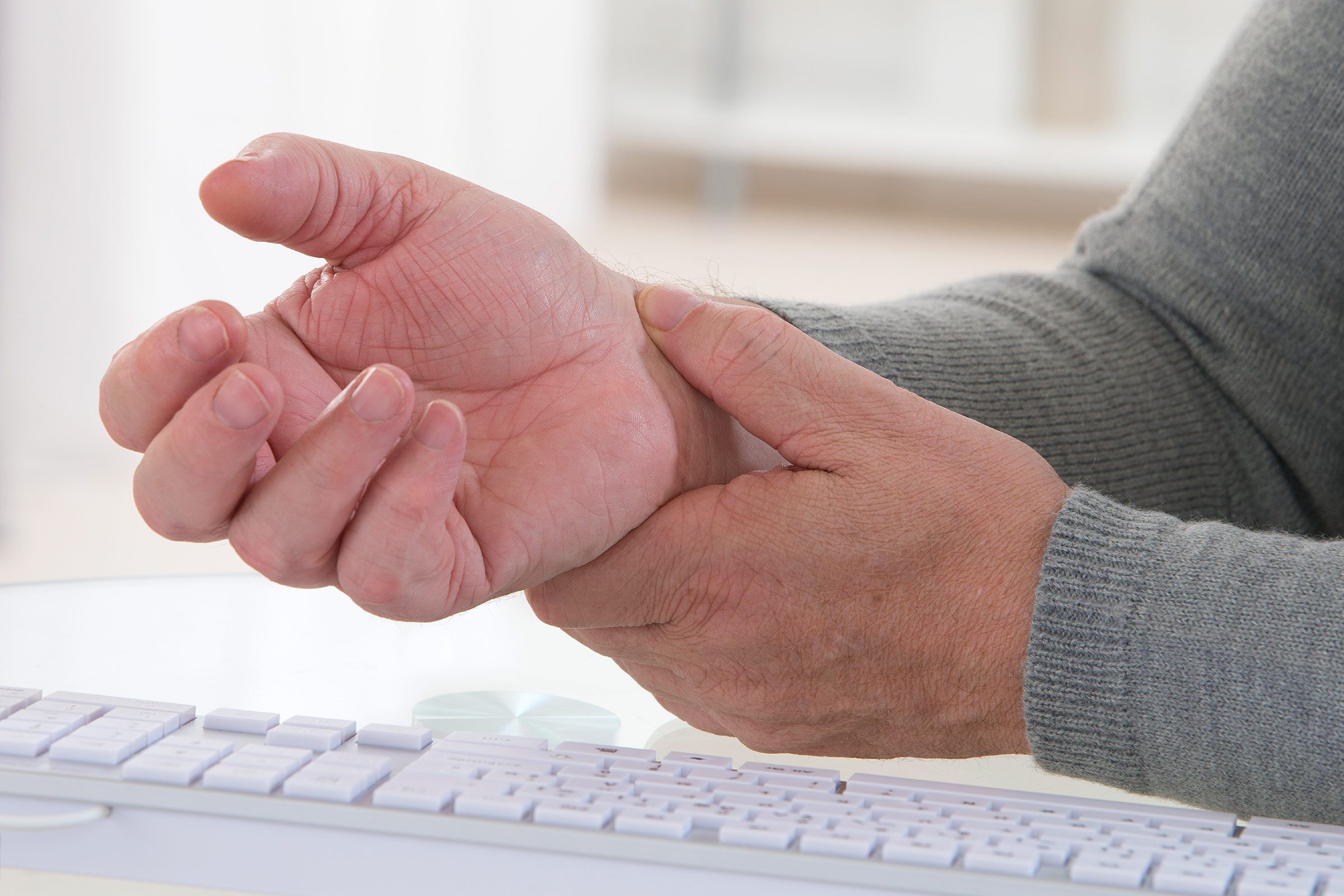 elderly person holding wrist