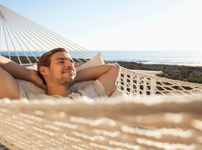 man laying in a hammock in the sun