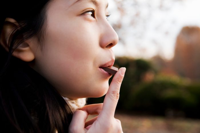 woman eating a piece of chocolate