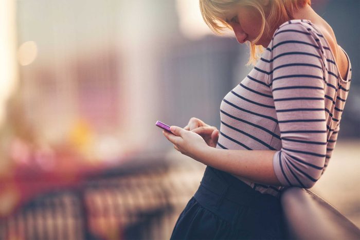 woman tapping on smartphone