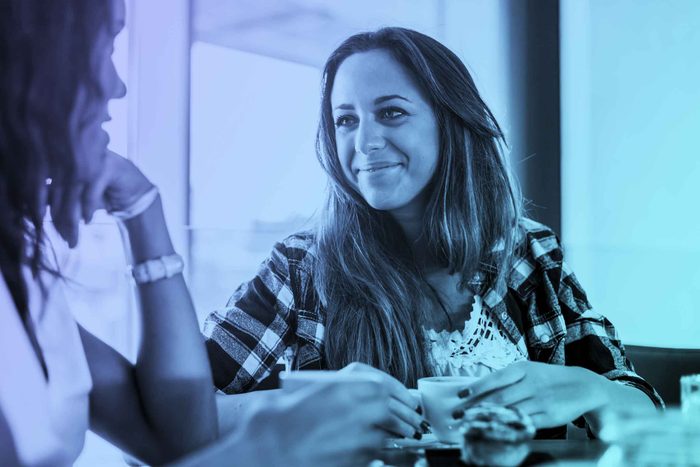 two women friends talking over coffee