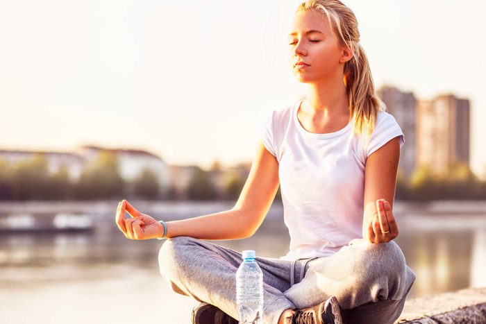 woman in cross-legged yoga pose outside