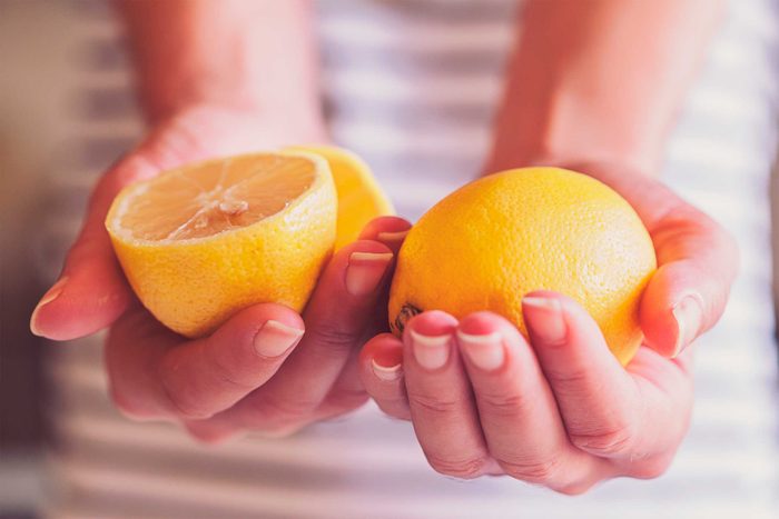 woman holding halves of an orange
