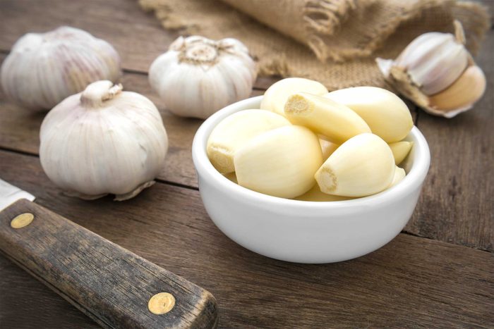 bulbs and cloves of garlic on a wooden surface
