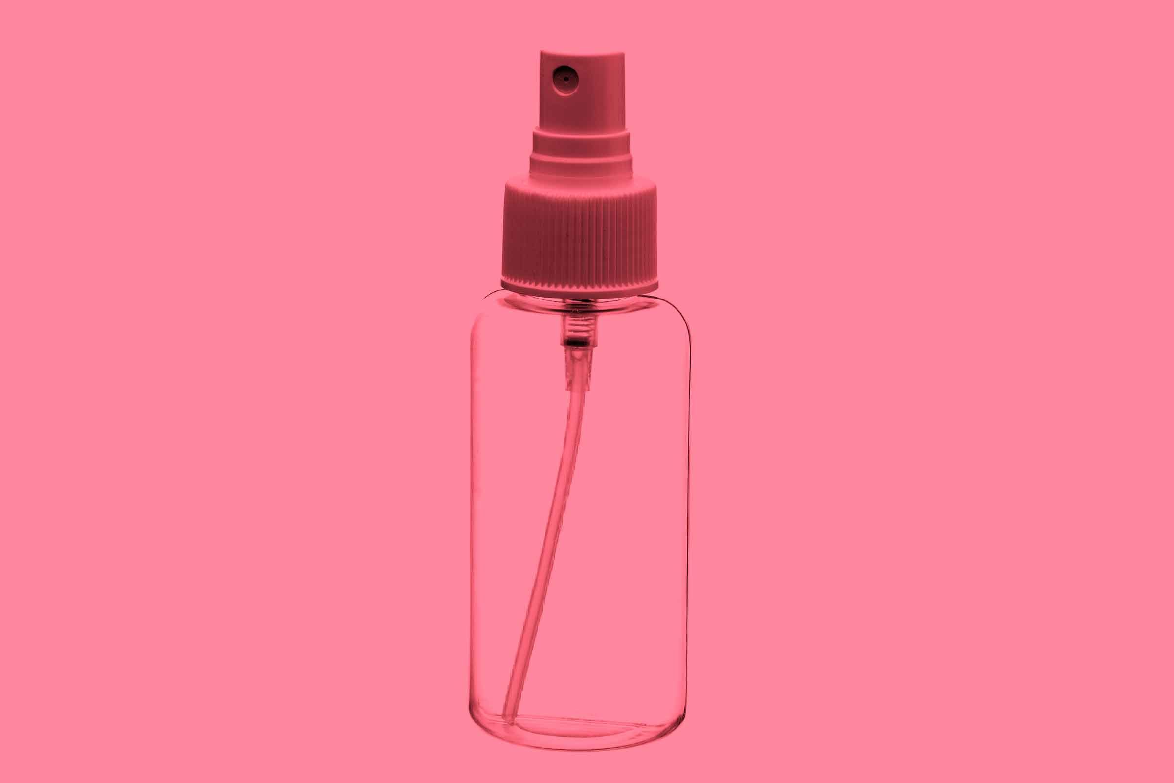 Clear bottle of rosewater on a pink background.