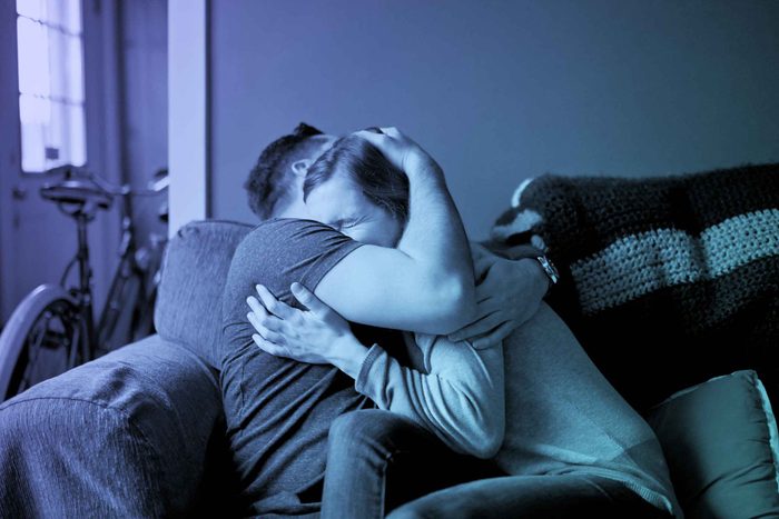 a couple embracing tightly on a couch