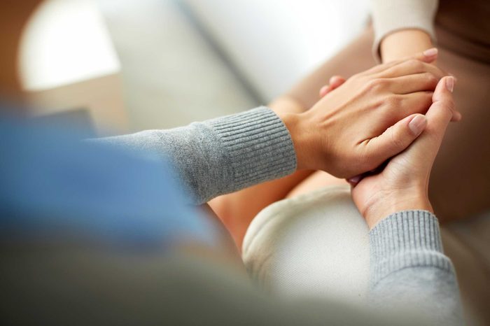 A woman holding a person's hand in both of her hands.