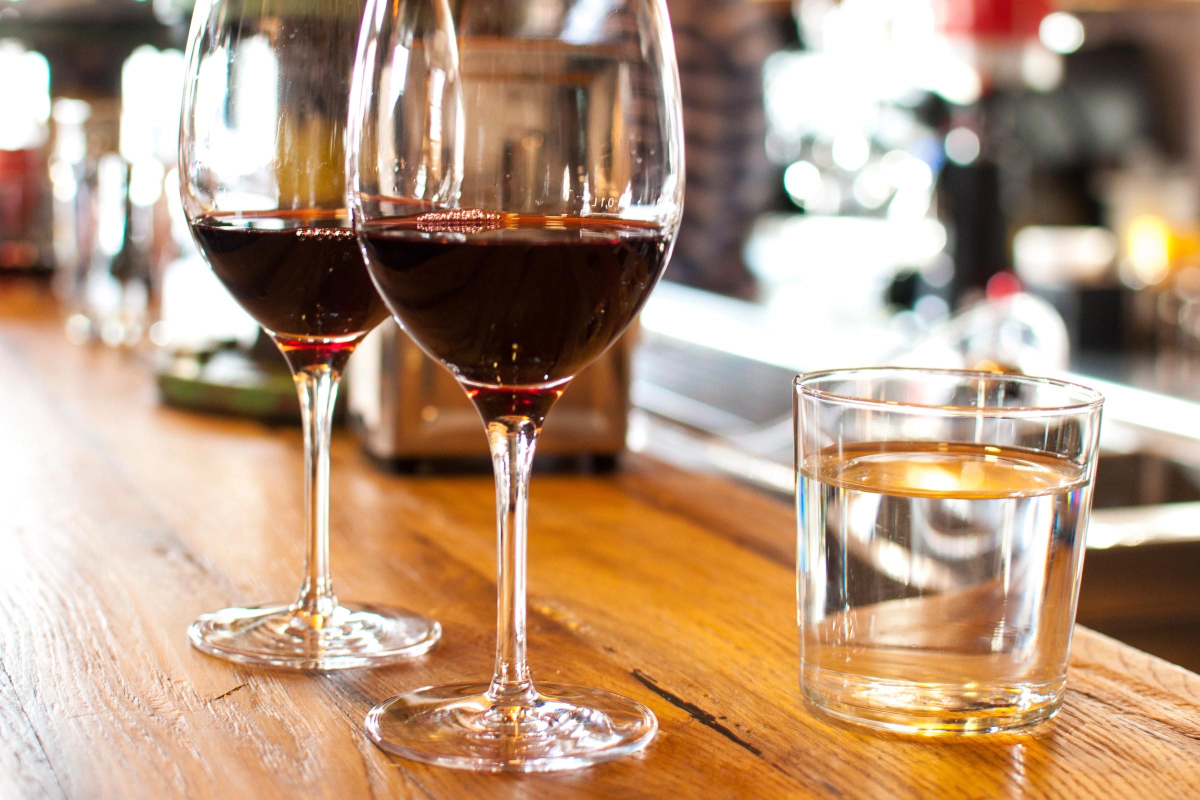 Glass of red wine on bar with water glass