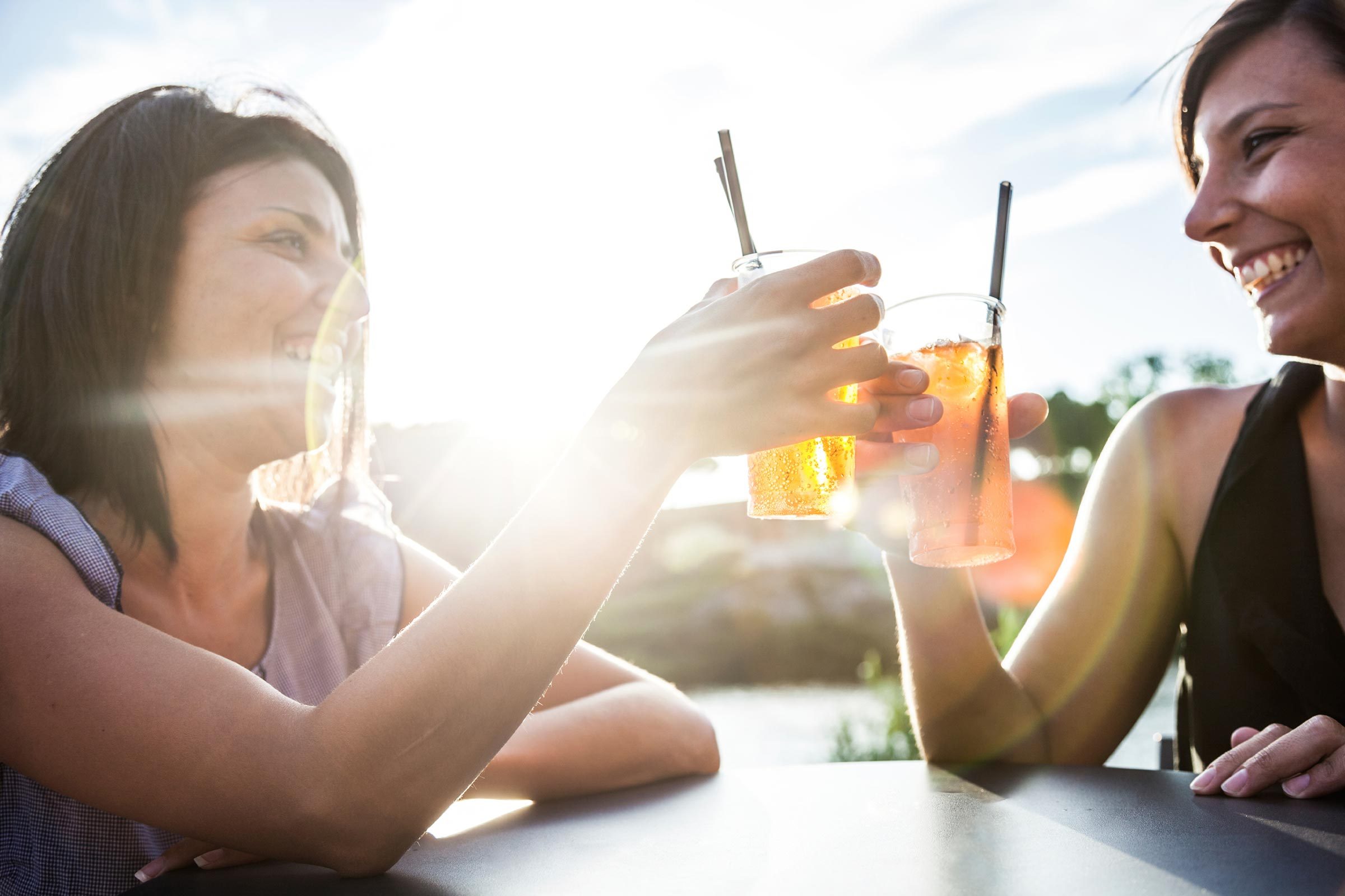 Women clinking glasses at sunset