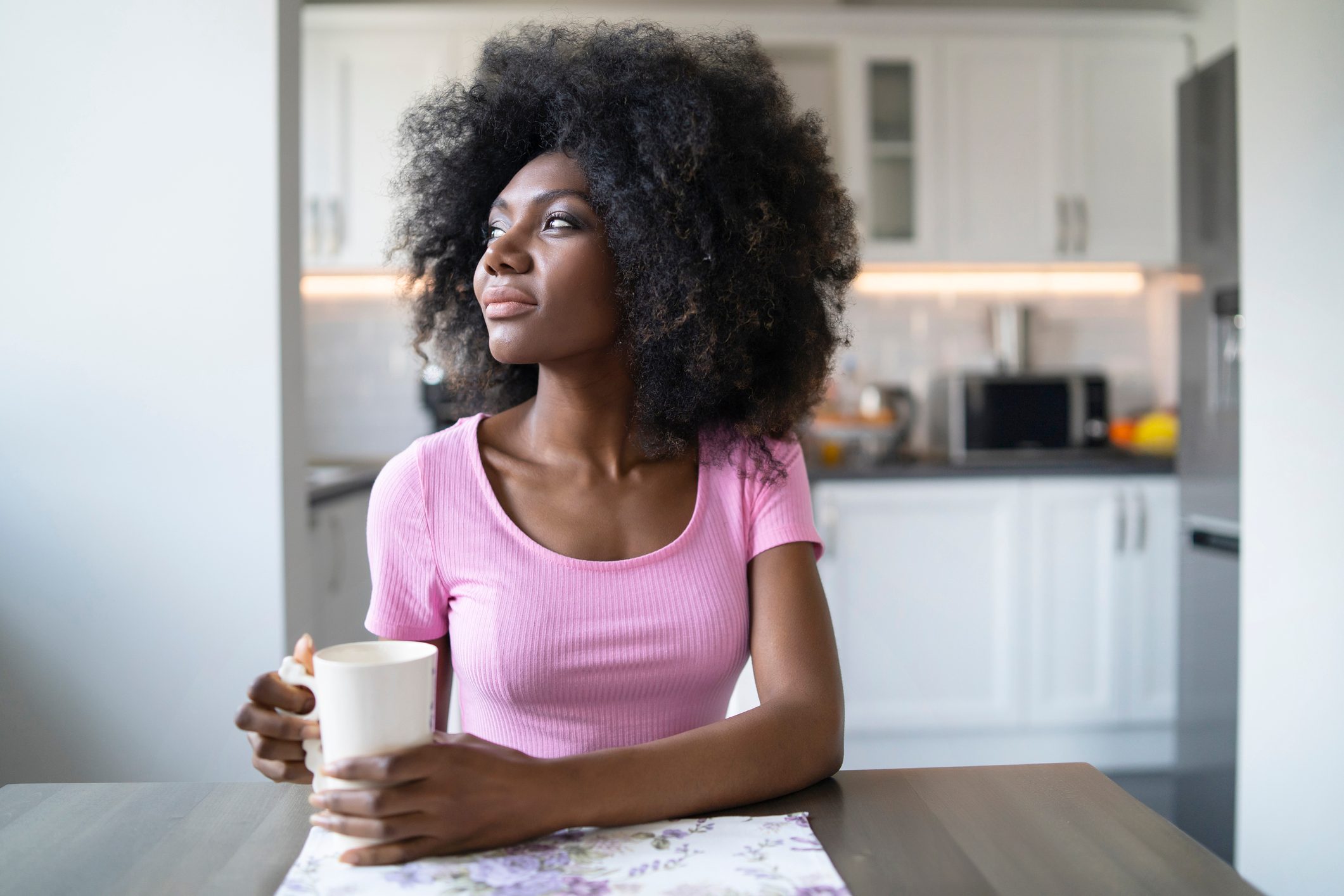 woman sitting at table at home looking away from camera