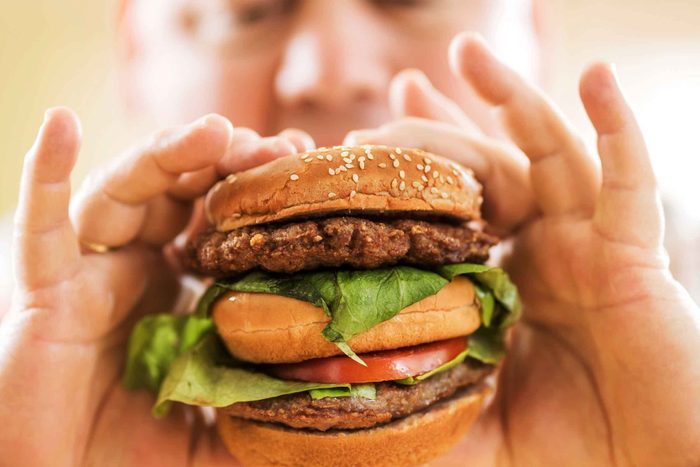 man holding a giant burger