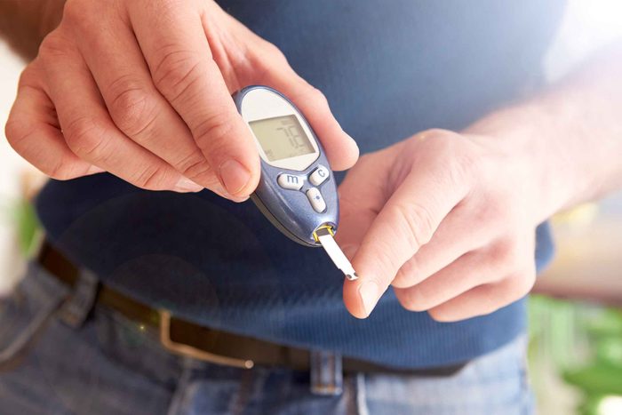 man checking his blood sugar with a device