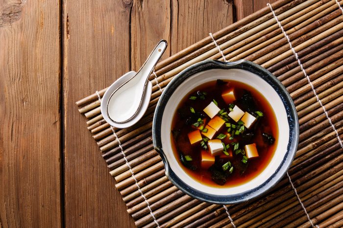 Bowl of miso soup on a mat.