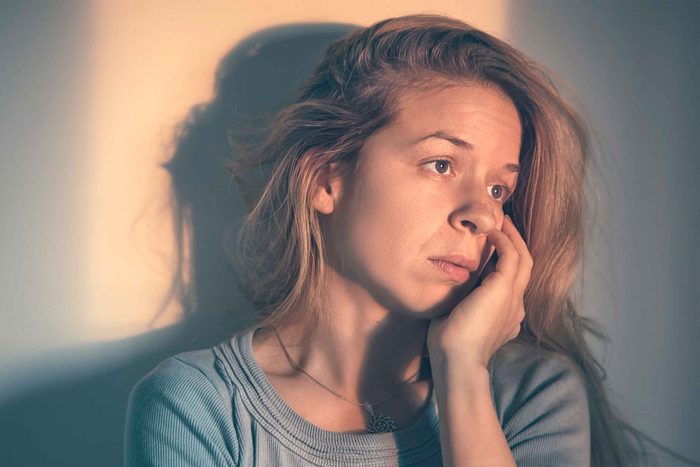woman with her head resting in her hand, bleary eyes